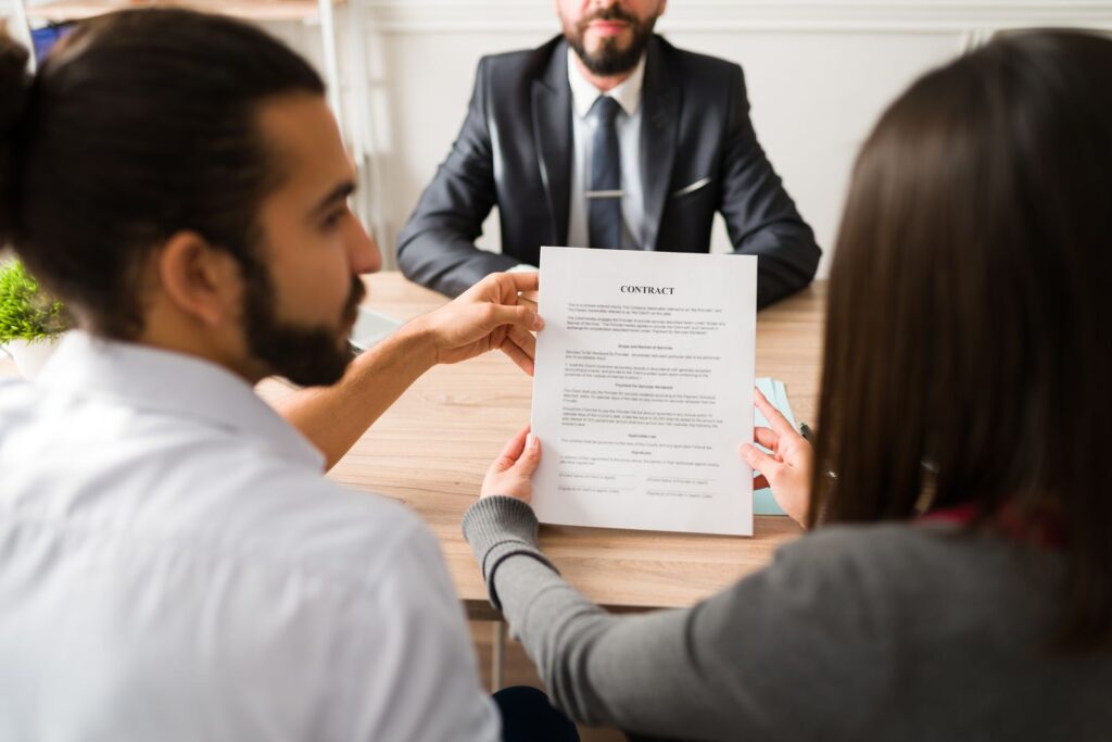 Couple reviewing legal paperwork with an attorney before filing a medical malpractice claim in New Jersey